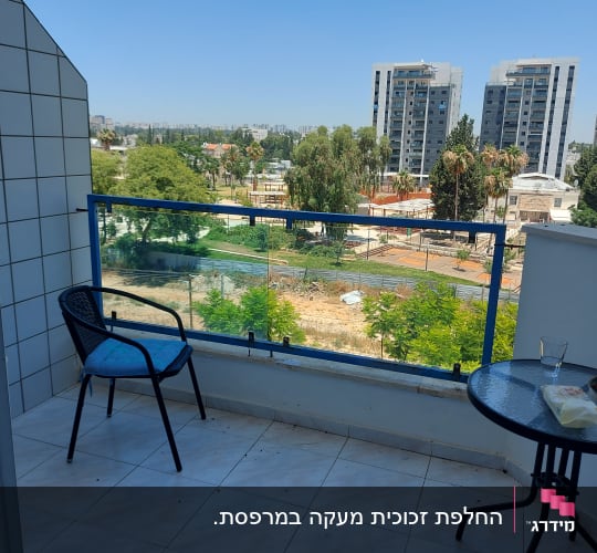 מעקה זכוכית במרפסת עם נוף עירוני